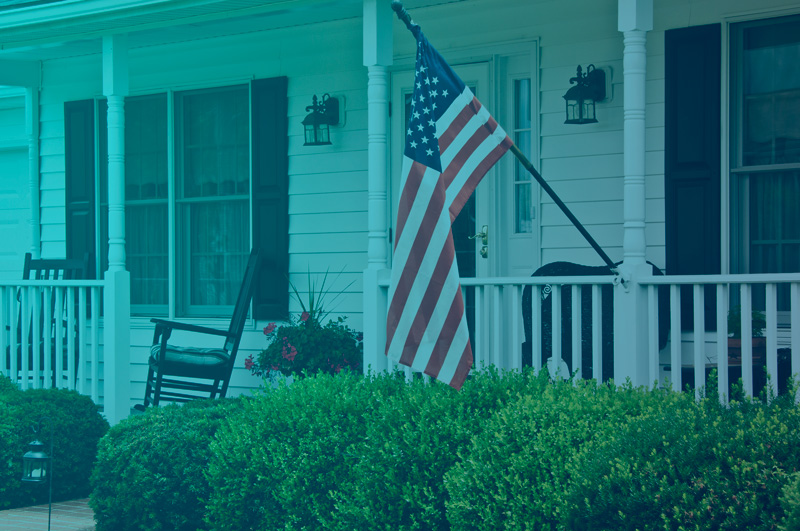 Front porch of house with American flag flying